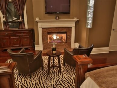 bedroom with blazing fireplace, 2 chairs with table in between