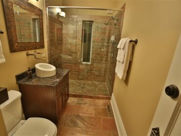 bathroom with shower, vanity basin, white towels