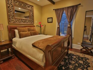 Euro bedroom with sleigh bed, beautiful mirror and luxurious linens