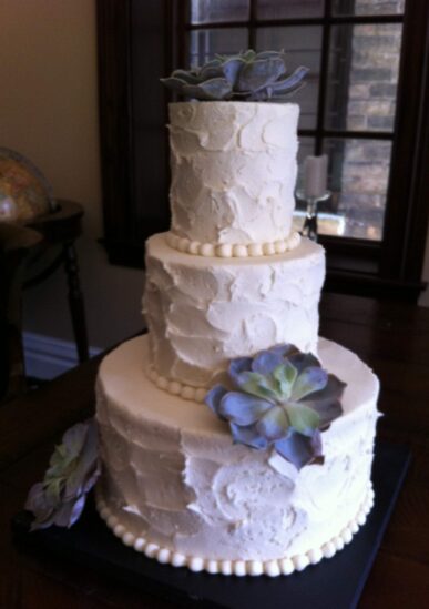 Wedding cake with white frosting and a decadent flower