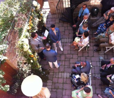 A wedding taking place in the courtyard with a beautiful arrangement of flowers